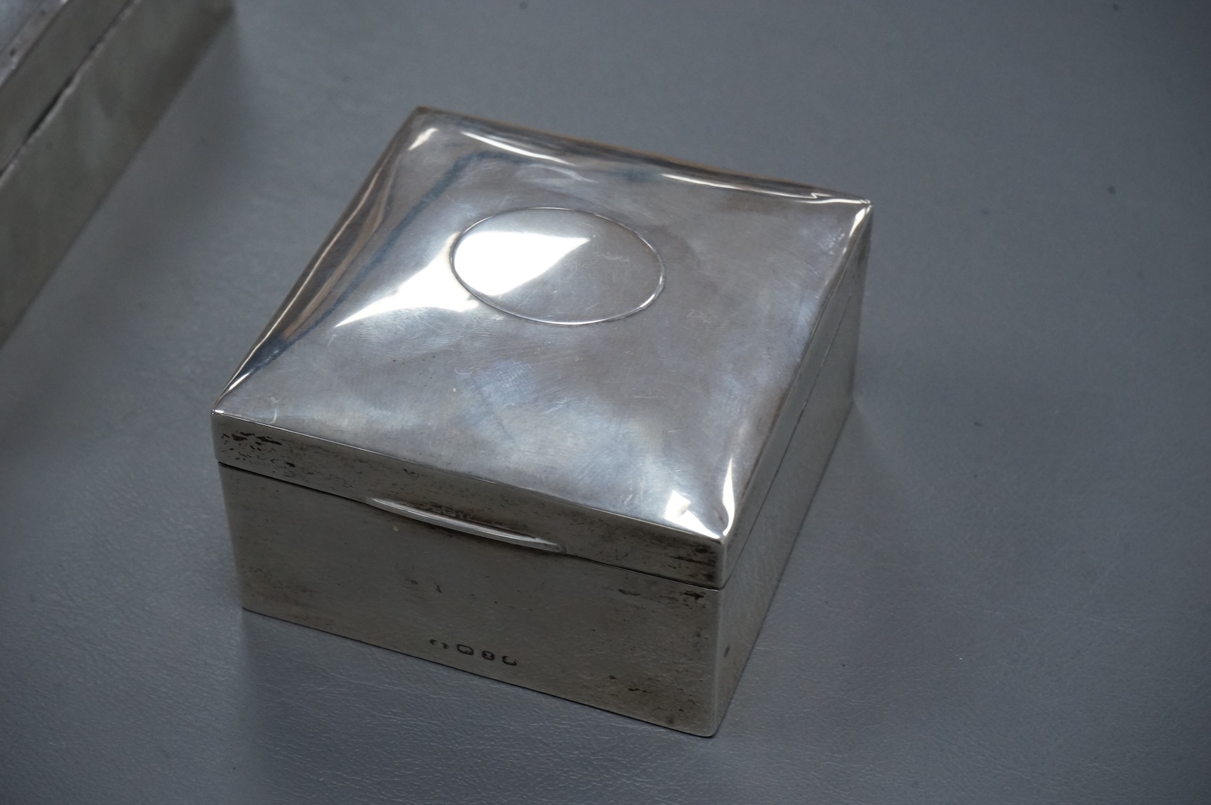 A George V silver mounted rectangular cigarette box, London, 1924, width 16cm, together with a smaller silver mounted cigarette box and a silver cigarette case.